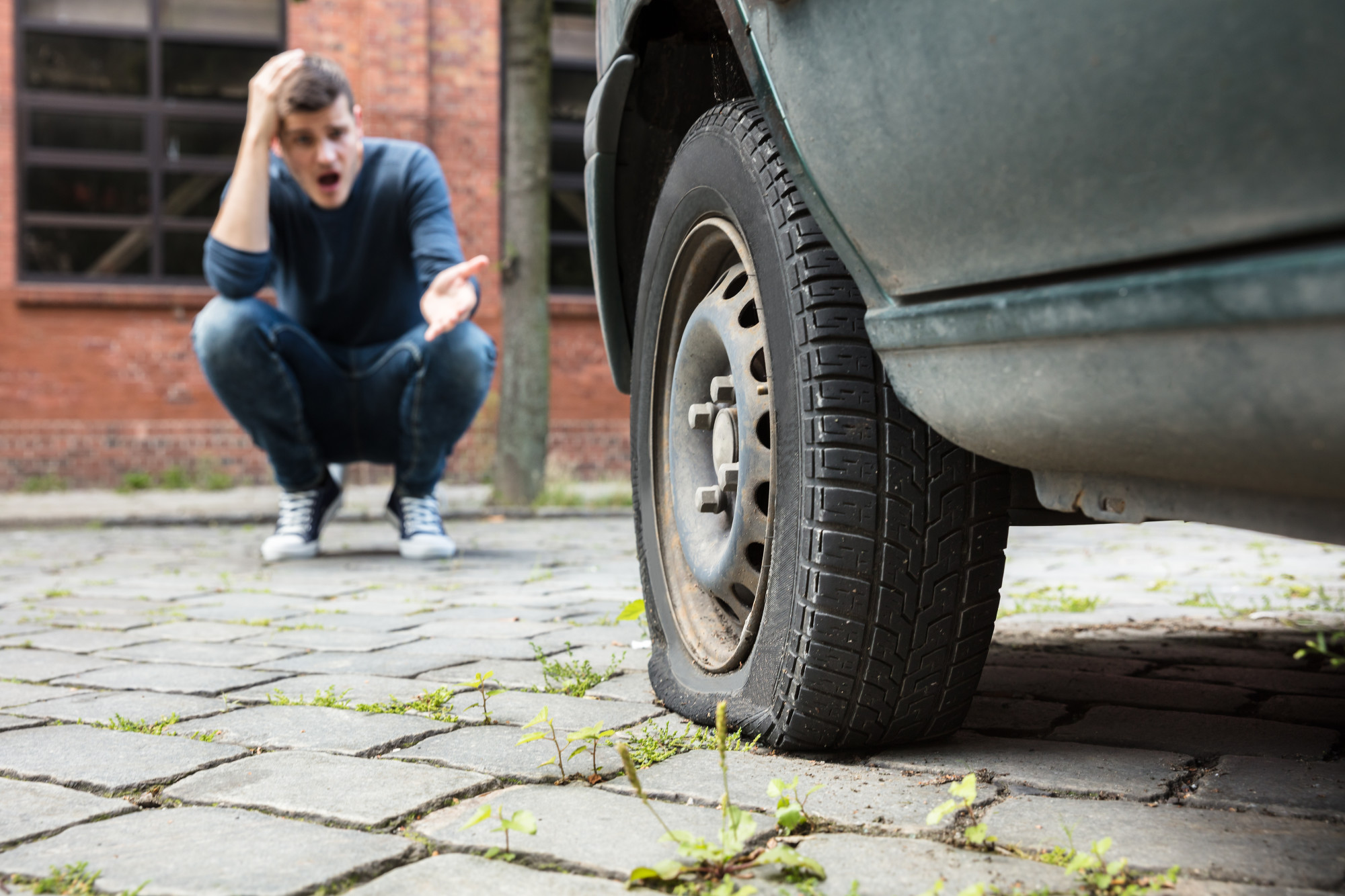 flat tire with man staring at it