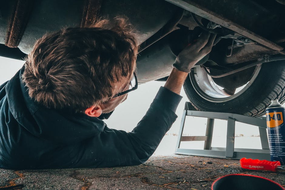 man fixing car from underneath
